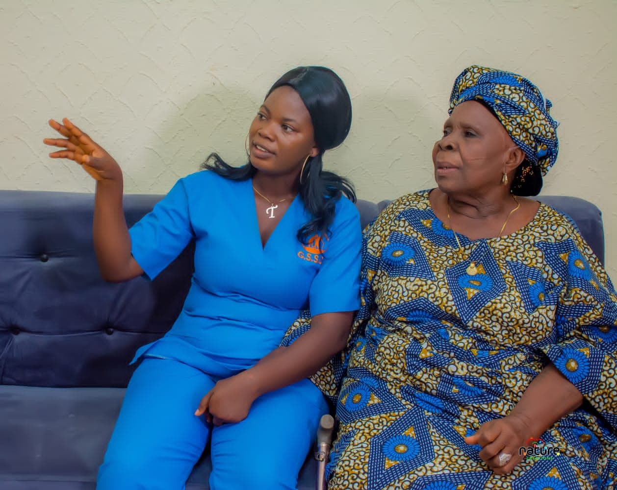 A Grace caregiver sitting with an older woman on a sofa